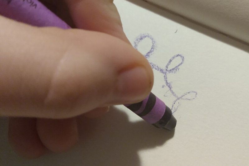A hand drawing with a purple wax crayon on white paper