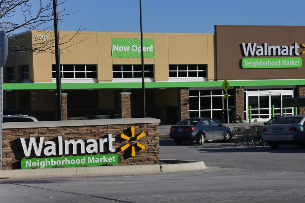 Walmart Neighborhood Market store front with a Now Open banner and a roadside Walmart sign